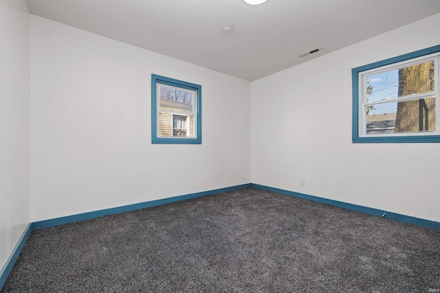 unfurnished room featuring baseboards, visible vents, and carpet floors