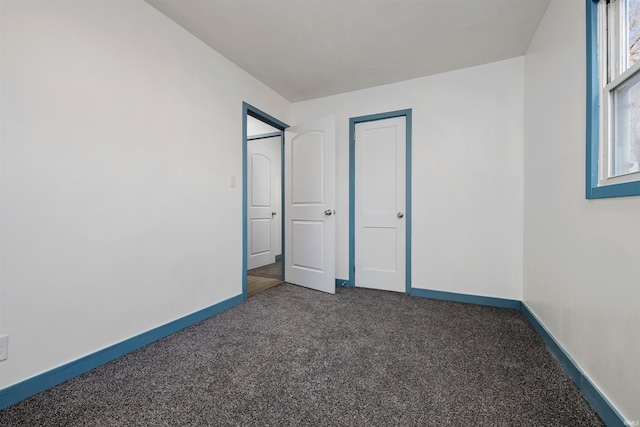 unfurnished bedroom featuring carpet and baseboards