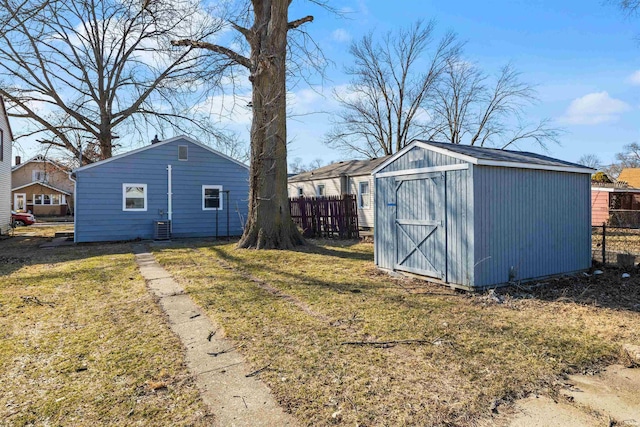 view of shed featuring central air condition unit and fence