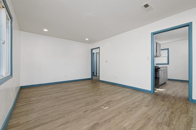 empty room featuring visible vents, recessed lighting, light wood-type flooring, and baseboards