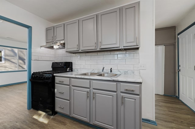 kitchen featuring gray cabinetry, gas stove, and a sink