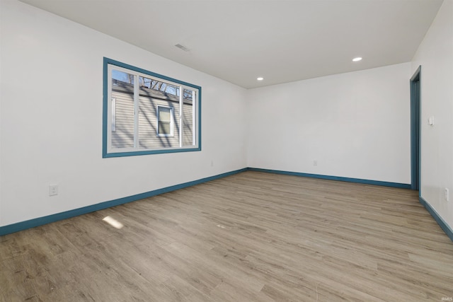 spare room with recessed lighting, light wood-style flooring, and baseboards