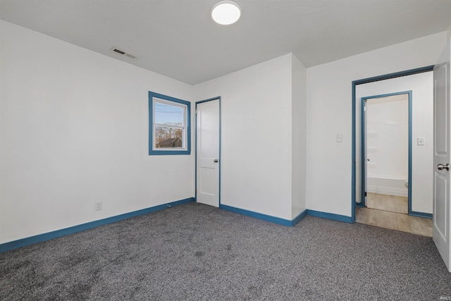 carpeted empty room featuring baseboards and visible vents