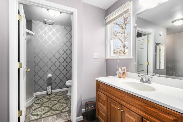 full bathroom featuring baseboards, toilet, and vanity