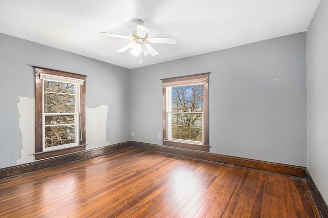 empty room featuring a ceiling fan, baseboards, and hardwood / wood-style floors