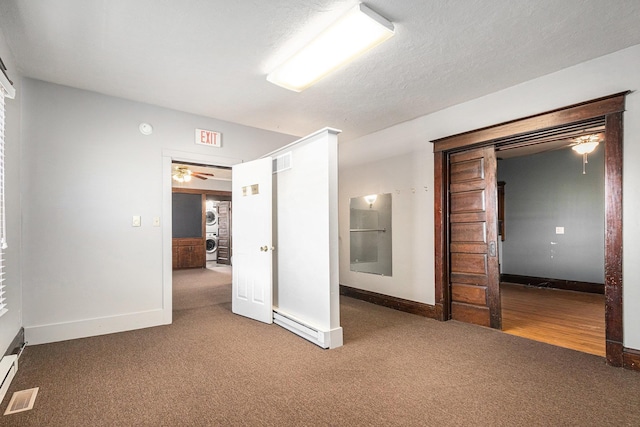 unfurnished bedroom featuring visible vents, stacked washer and clothes dryer, a textured ceiling, and carpet floors