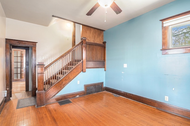 stairway featuring visible vents, baseboards, a ceiling fan, and wood-type flooring