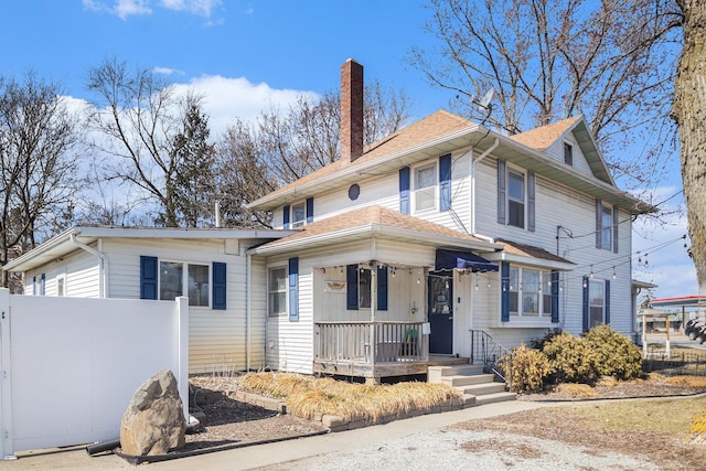 view of front of property with fence, roof with shingles, and a chimney