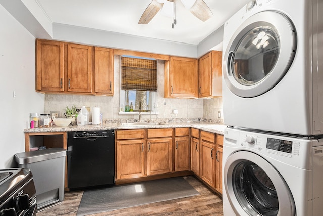 clothes washing area featuring a sink, wood finished floors, stacked washing maching and dryer, ceiling fan, and laundry area