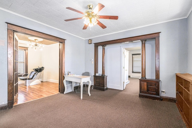 carpeted office space featuring crown molding, baseboards, and ceiling fan