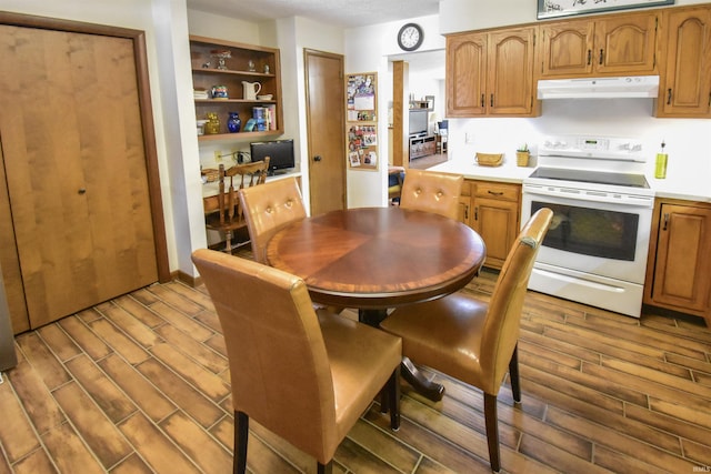 kitchen with under cabinet range hood, light countertops, wood tiled floor, and white range with electric cooktop