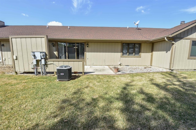 back of property featuring cooling unit, a lawn, and roof with shingles