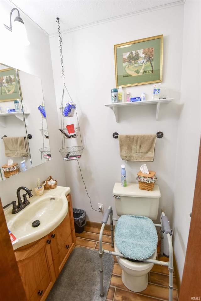 half bathroom featuring crown molding, toilet, vanity, and baseboards