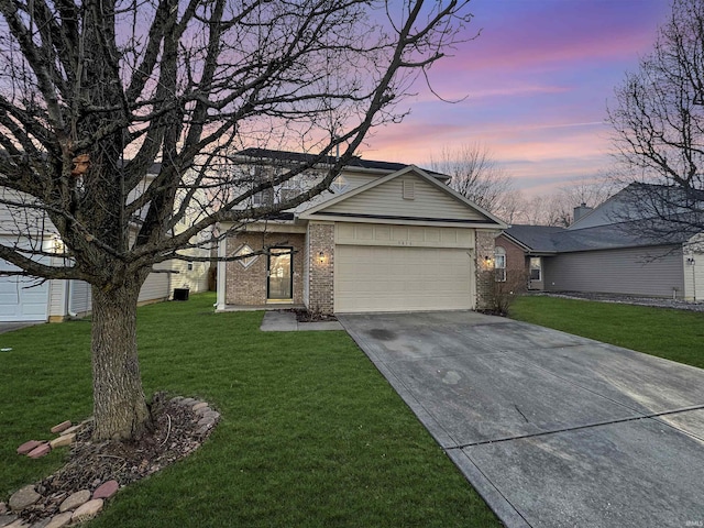 view of front of property with brick siding, a garage, a front lawn, and driveway