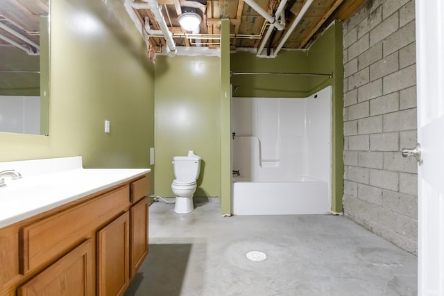 bathroom featuring vanity, unfinished concrete floors, concrete block wall, tub / shower combination, and toilet