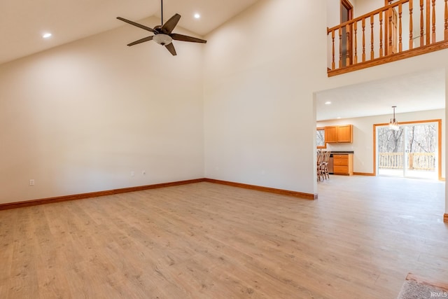 unfurnished living room with light wood-type flooring, high vaulted ceiling, a ceiling fan, recessed lighting, and baseboards