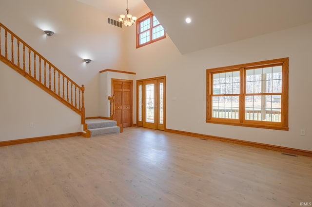 foyer featuring visible vents, a notable chandelier, wood finished floors, and stairs