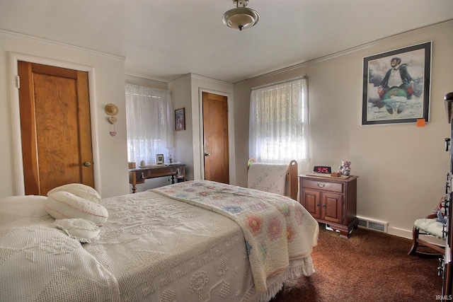 bedroom featuring baseboards, visible vents, and dark colored carpet