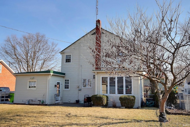 back of house featuring a lawn and fence