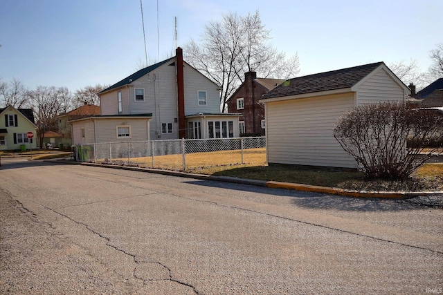 back of house with a chimney and fence