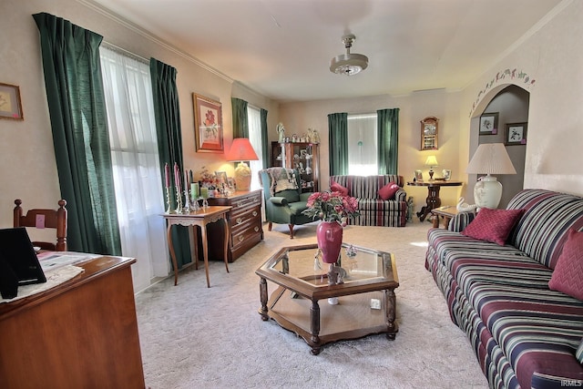 living room featuring plenty of natural light, light carpet, and ornamental molding