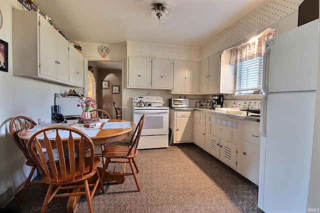 kitchen with white appliances, white cabinets, and a toaster