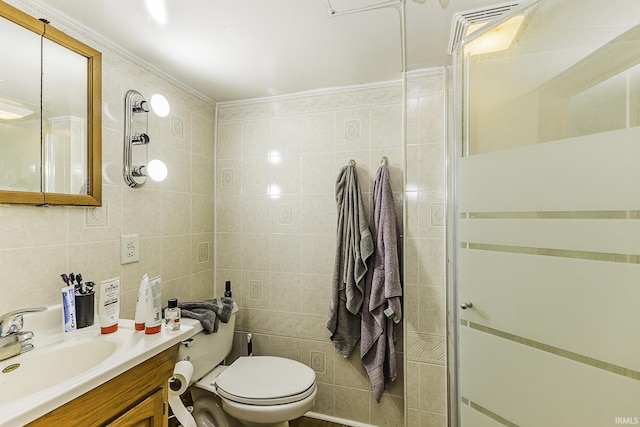 bathroom featuring toilet, a stall shower, tile walls, and vanity