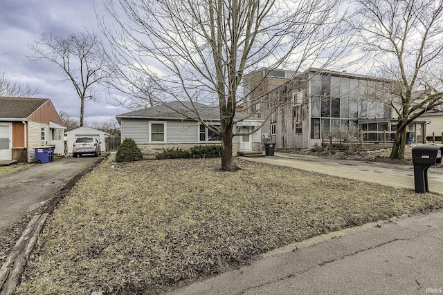 view of front of house with aphalt driveway and an outdoor structure