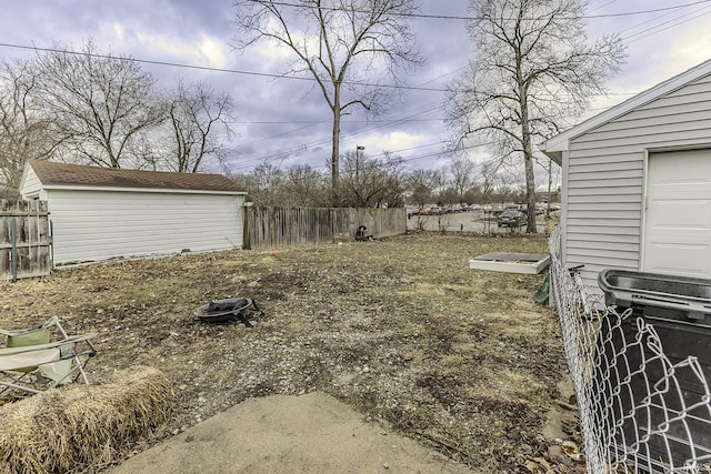 view of yard with an outdoor structure, a shed, and fence