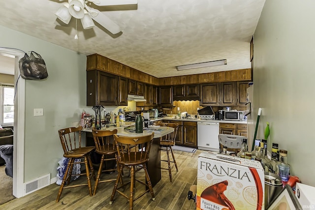 kitchen with a ceiling fan, visible vents, under cabinet range hood, dishwasher, and stainless steel microwave