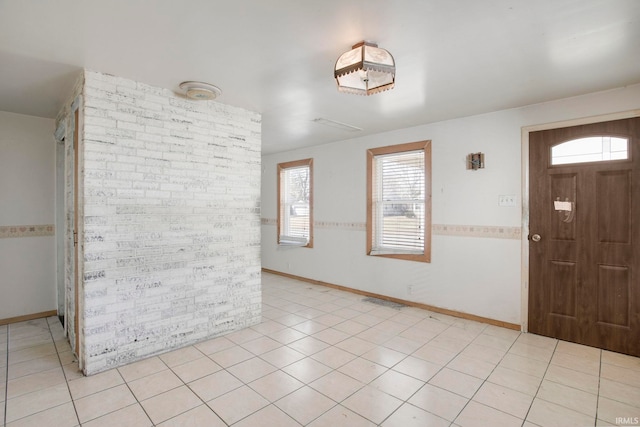 foyer with light tile patterned floors, a healthy amount of sunlight, and baseboards