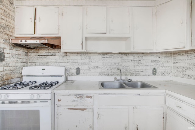 kitchen with white cabinetry, gas range gas stove, under cabinet range hood, and a sink