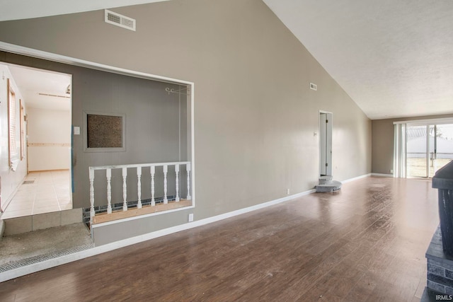 unfurnished living room featuring visible vents, high vaulted ceiling, baseboards, and wood finished floors