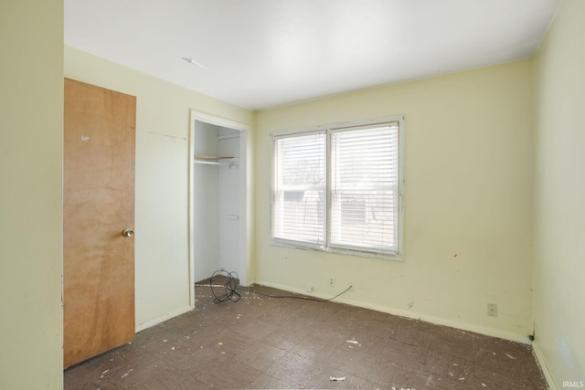 unfurnished bedroom with tile patterned floors, baseboards, and a closet