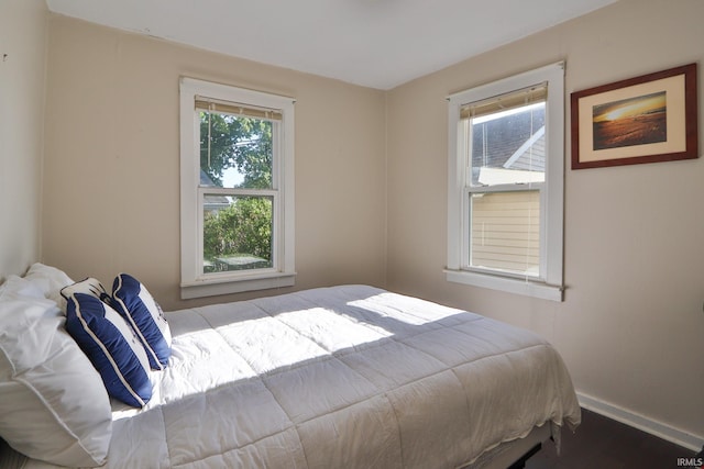 bedroom with baseboards and wood finished floors