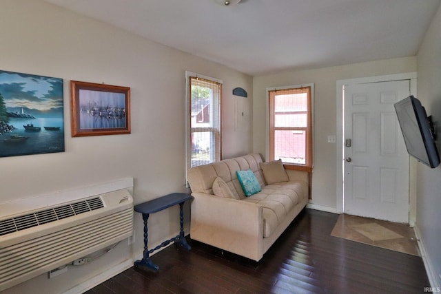 living room with a wall mounted AC, dark wood-type flooring, and baseboards