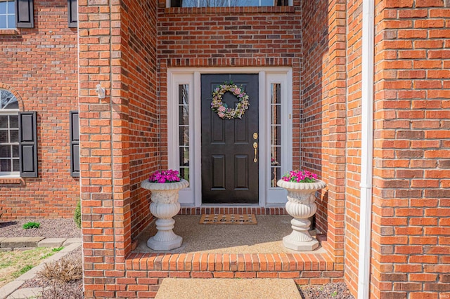 doorway to property with brick siding