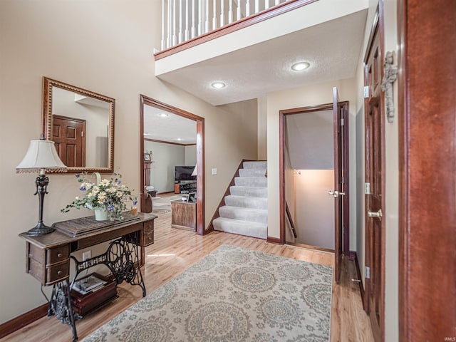 hall with recessed lighting, baseboards, stairs, and light wood finished floors