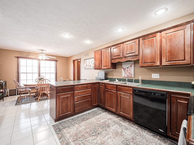 kitchen featuring a ceiling fan, a sink, black dishwasher, a peninsula, and light tile patterned floors