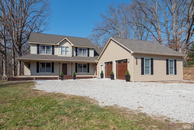 view of front of home featuring covered porch, an attached garage, gravel driveway, and a front yard