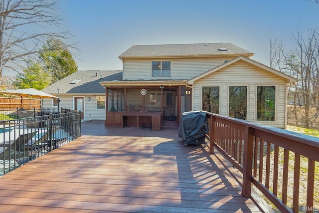 wooden terrace featuring area for grilling and fence