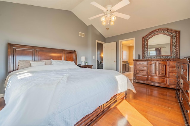 bedroom with visible vents, ceiling fan, lofted ceiling, ensuite bathroom, and wood finished floors