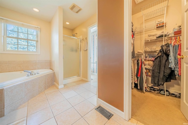 full bathroom featuring tile patterned floors, a spacious closet, visible vents, and a shower stall