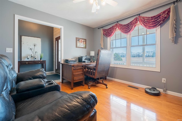 office space featuring a ceiling fan, wood finished floors, visible vents, and baseboards