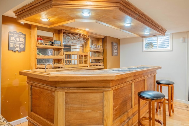 bar featuring light wood-style flooring, a dry bar, and baseboards