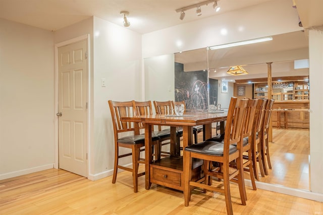 dining space with baseboards and wood finished floors