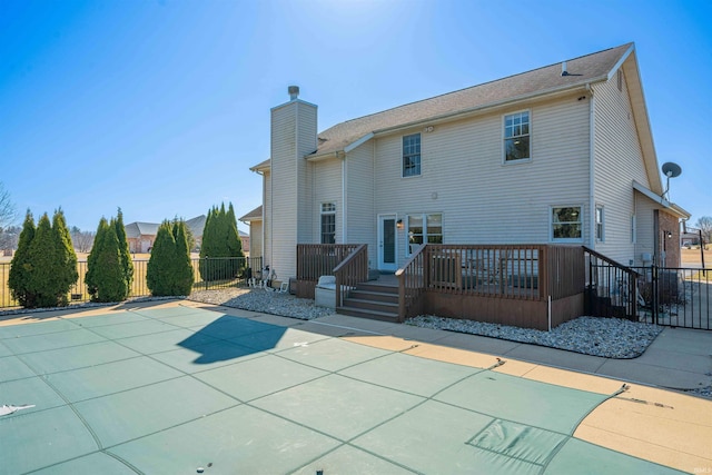 back of house featuring a patio, a deck, a chimney, and fence