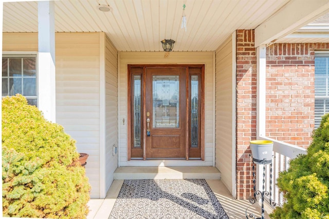 view of exterior entry with brick siding