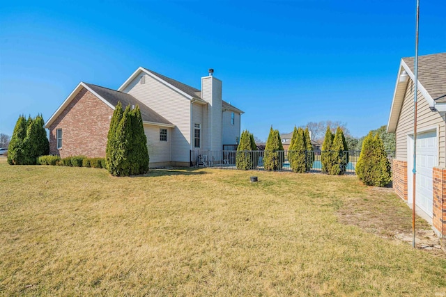 view of side of home with a lawn and fence