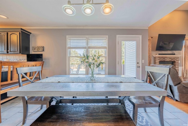 dining room featuring ornamental molding and a fireplace